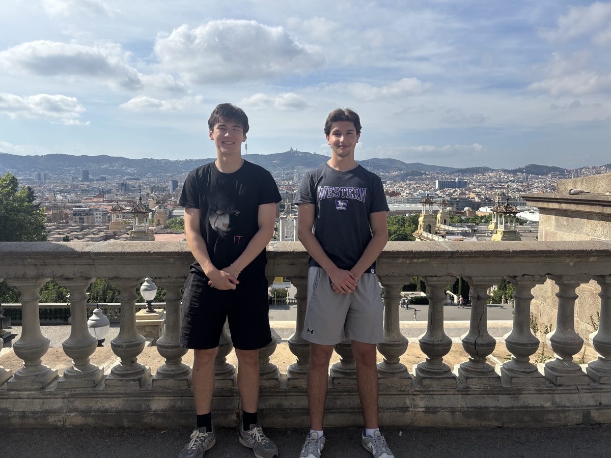 Marc and a friend standing at a stone balustrade on Montju&iuml;c, with Barcelona and the hills behind the city stretching out below.