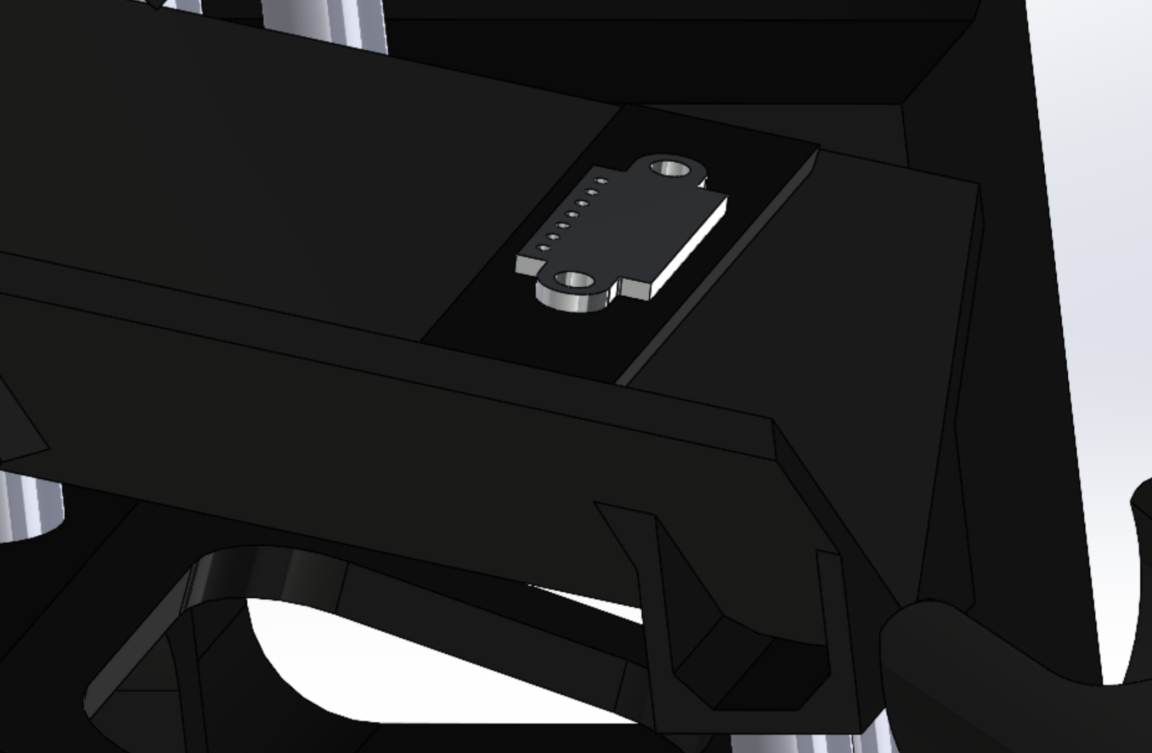 CAD close-up of the colour sensor board seated in a recess in the wall of the black chute, its sensing face level with the gap an eraser passes through.